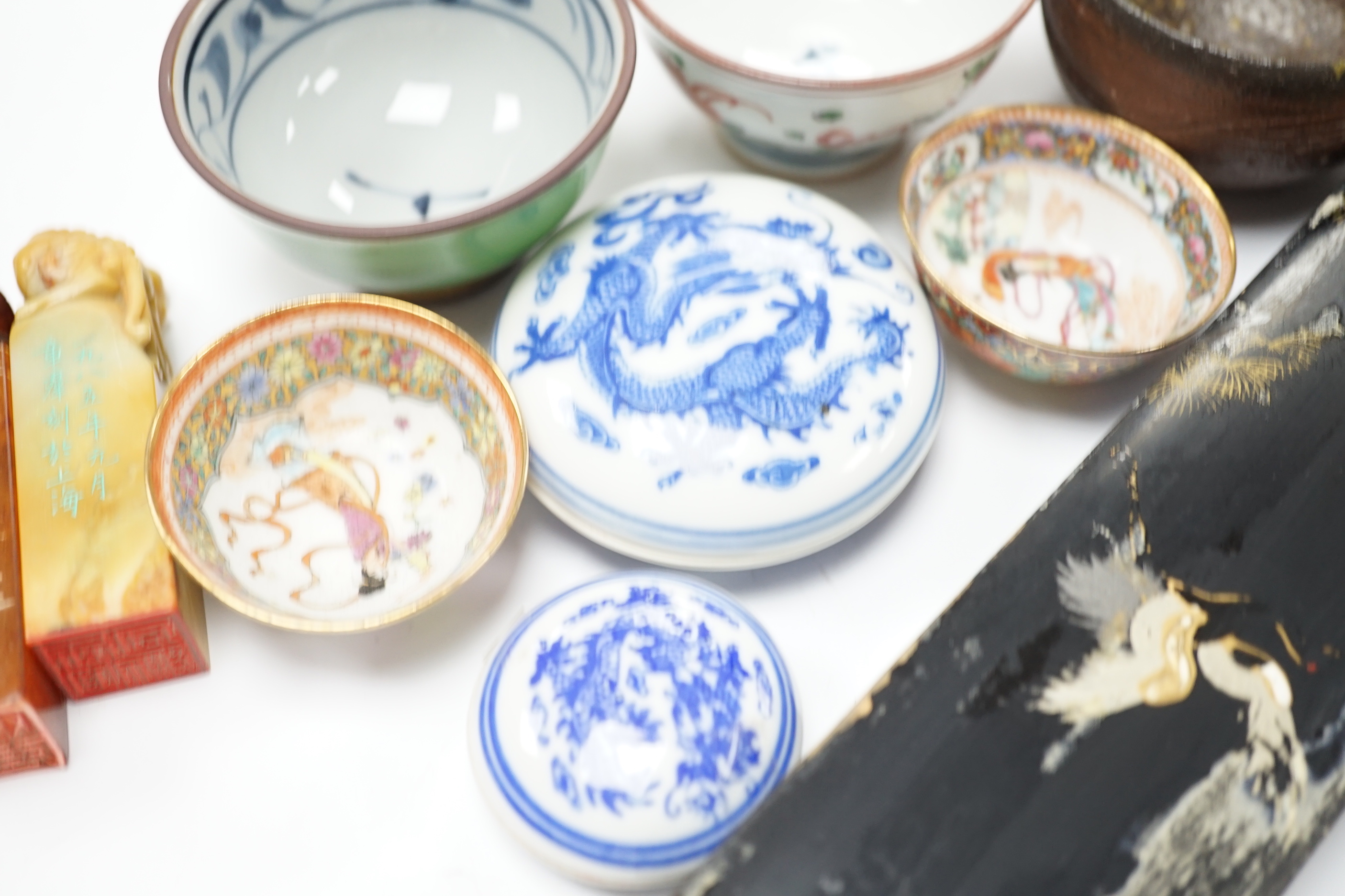 A group of Chinese and Japanese ceramics and works of art including two carved seals and tea bowls housed in a red lacquered box